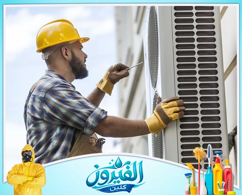 تنظيف مكيفات في الجبيل 0562185880 شركة الفيروز فني محترف يرتدي خوذة وقفازات، يقوم بصيانة دقيقة لوحدة تكييف خارجية لضمان كفاءة التبريد واستمرارية الأداء العالي.