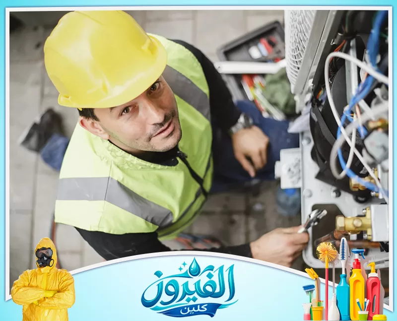 تركيب مكيفات القطيف 0562185880 شركة الفيروز فني تكييف محترف يرتدي خوذة الأمان أثناء صيانة وإصلاح الوحدة الخارجية للمكيف