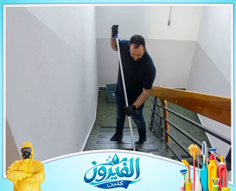 تنظيف سلالم العمائر برأس تنورة 0562185880 شركة الفيروز مشهد لعامل يستخدم ممسحة طويلة لتنظيف سلالم المبنى.