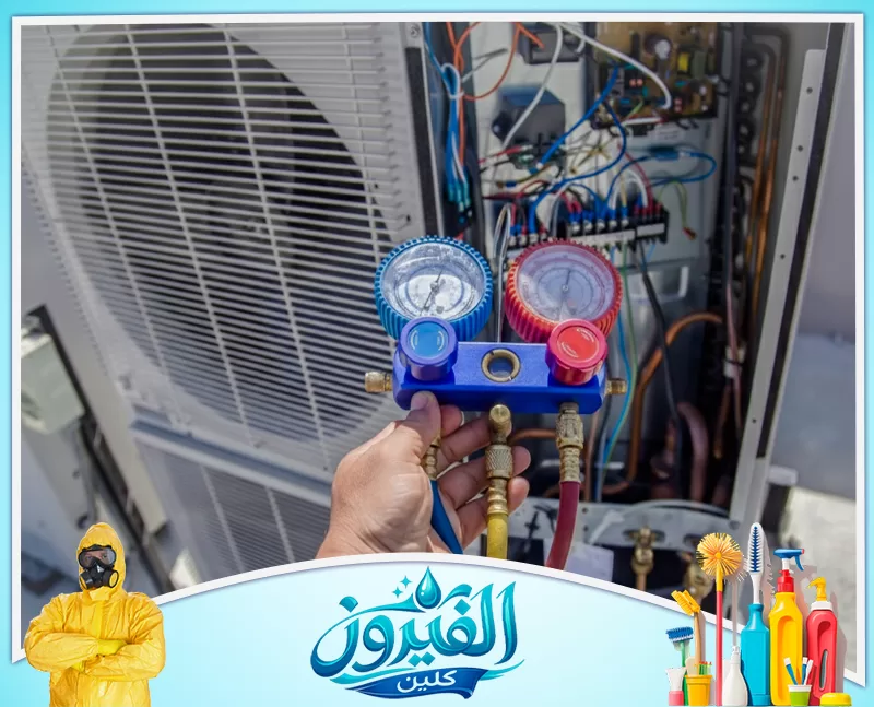 صيانة مكيفات صحراوي في الظهران 0562185880 شركة الفيروز فنيّ تحمل مقياس ضغط مزدوج (أزرق وأحمر) موصول بخراطيم أمام وحدة تكييف خارجية مفتوحة تظهر أسلاكها