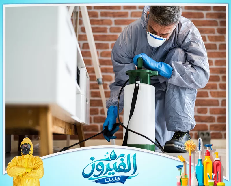 مكافحة الفئران بالقطيف 0562185880 شركة الفيروز فني مكافحة حشرات يرتدي بذلة واقية كاملة وكمامة، يستخدم مضخة رش يدوية لتطهير المنزل بعناية ودقة خلف الأثاث.