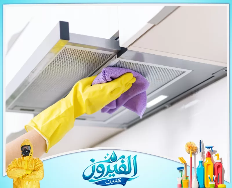 تنظيف مداخن المطاعم بالظهران 0562185880 شركة الفيروز يد ترتدي قفازًا أصفر وتمسك بقطعة قماش بنفسجية تمسح بها مرشح شفاط مطبخ معدني استعدادًا لتنظيفه.