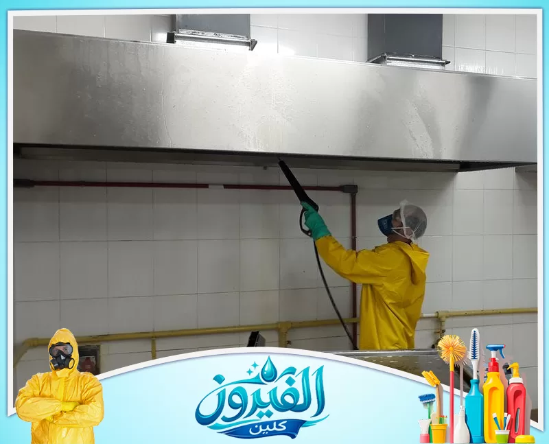 تنظيف هود المطاعم بالخبر 0562185880 شركة الفيروز عامل يرتدي ملابس وقائية يستخدم جهاز ضغط المياه لتنظيف وتطهير شفاط مطعم تجاري من الدهون والأوساخ المتراكمة.