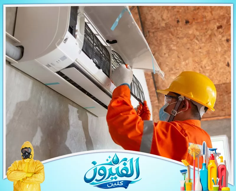تصليح مكيفات شباك في الجبيل 0562185880 شركة الفيروز فني بزي برتقالي وخوذة يركب فلتر مكيف الهواء بدقة، لضمان تشغيل آمن وهواء نظيف في الموقع.