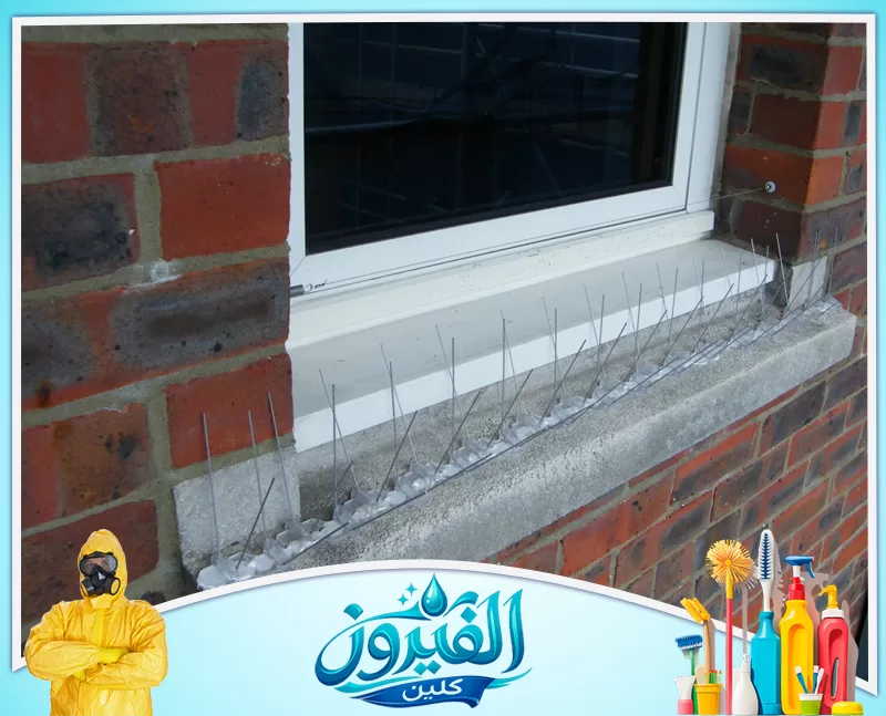 طارد حمام للمكيفات في الخبر 0562185880 شركة الفيروز أشواك معدنية رفيعة مثبتة على حافة نافذة خارجية في جدار من الطوب الأحمر، مصممة لمنع الطيور من الهبوط أو الاستيطان.