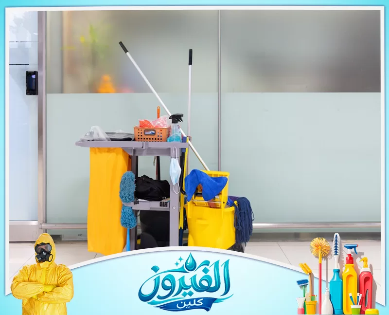 شركة تنظيف حمامات بالدمام 0562185880 شركة الفيروز عربة تنظيف ودلو ومماسح أمام واجهة زجاجية، مناسبة للتعبير عن تنظيف المكاتب والمنشآت.
