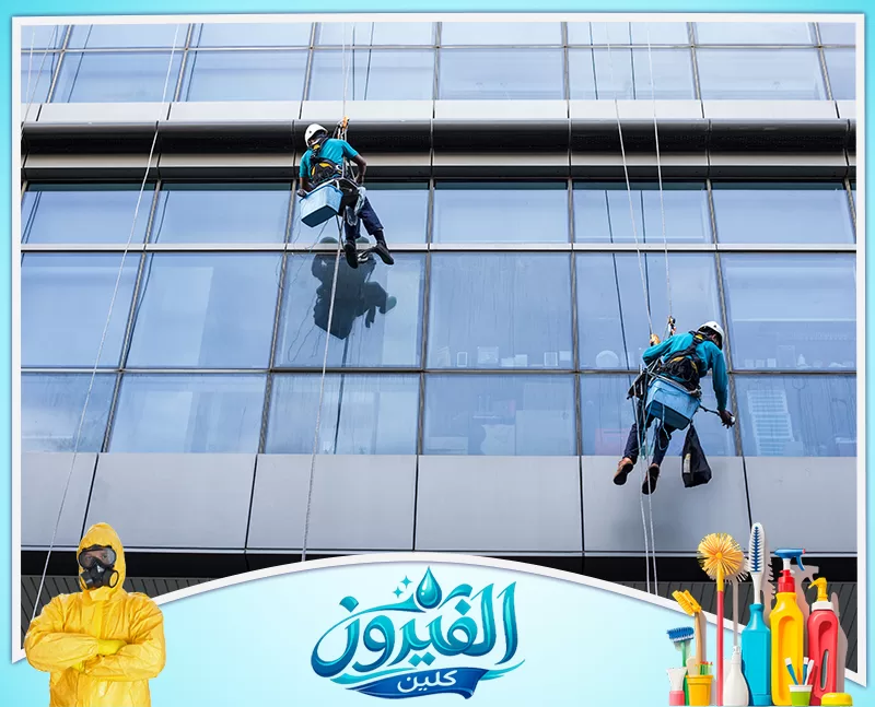 فني ينظف واجهة زجاجية كبيرة ويزيل الأتربة والبقع
