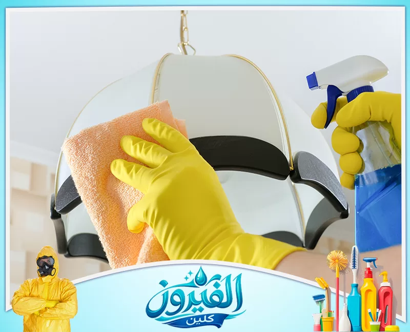 فني ينظف نجفة كبيرة بعناية داخل منزل في الدمام